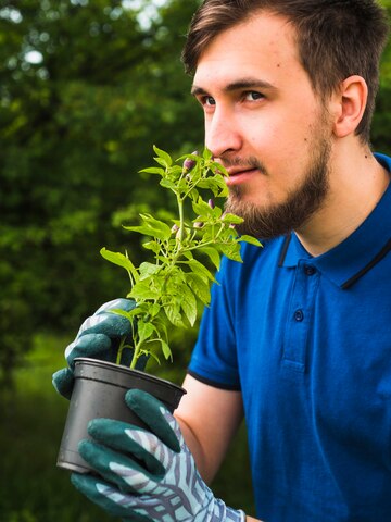 Young man smelling the potted plant<br />